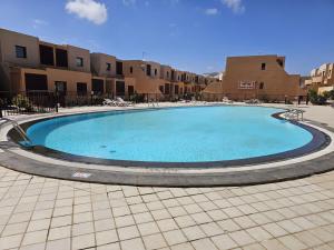 uma grande piscina num pátio com edifícios em Diamante de la Bahia em Caleta de Fuste