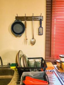 un estante de platos con platos y utensilios en la cocina en San Juan Loft, en Santiago de Veraguas