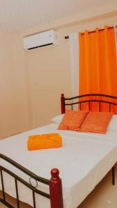 a bedroom with a bed with an orange curtain at San Juan Loft in Santiago