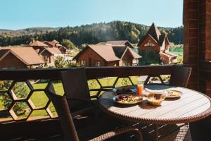 stół z talerzem jedzenia na balkonie w obiekcie TAOR Karpaty Resort & Spa w mieście Schodnica