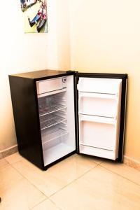a black refrigerator with its door open in a kitchen at San Juan Loft in Santiago