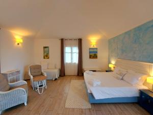a bedroom with a bed and two chairs and a window at Hotel La Villa Del Mare in Cagliari