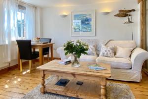 a living room with a couch and a table at Althea House with parking in Padstow