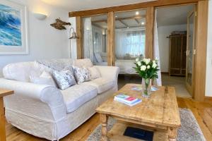 a living room with a white couch and a table at Althea House with parking in Padstow