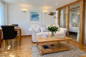 a living room with a couch and a table at Althea House with parking in Padstow