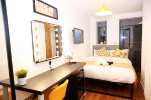 1 dormitorio con cama y escritorio con espejo en London City Self Check-in Luxury Rooms en Londres