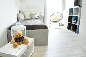 a teddy bear sitting on a table in a bedroom at Storchenblick-No-1 in Winsen Luhe