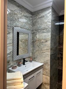 een badkamer met een wastafel en een spiegel bij GT apartments in Chisinau in Chişinău