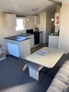 una pequeña cocina con mesa y barra en Family Caravan, Seton sands, Haven holiday village, en Port Seton