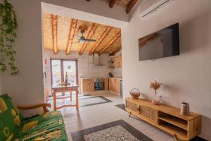 Casa Rural El Olivo في Villamalea: غرفة معيشة مع أريكة وتلفزيون على الحائط