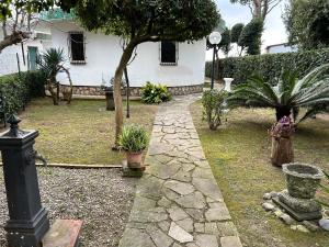 einen Garten mit einem Steinpfad vor einem Haus in der Unterkunft Fronte Mare Villa Acquasanta zona "LA FIUMETTA" Terracina in Terracina