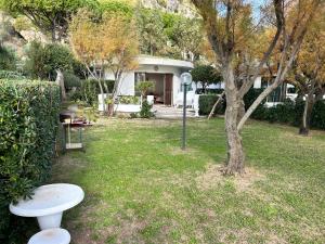 ein Haus mit einem Tisch und einem Baum im Hof in der Unterkunft Fronte Mare Villa Acquasanta zona "LA FIUMETTA" Terracina in Terracina