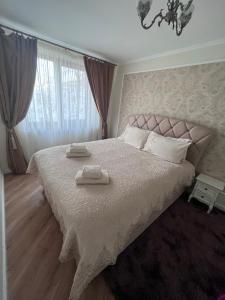 a bedroom with a large bed with two towels on it at Apartament in Botosani in Botoşani