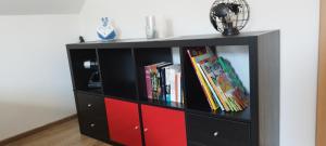 a black and red book shelf with books at Ferienwohnung Fabian in Stainach