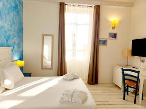 a bedroom with a bed and a desk and a window at Hotel La Villa Del Mare in Cagliari