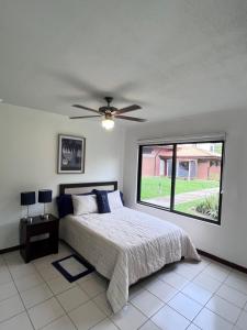 a bedroom with a bed and a ceiling fan at Liberia vacational condo in Liberia