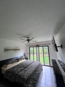 a bedroom with a bed and a ceiling fan at Liberia vacational condo in Liberia