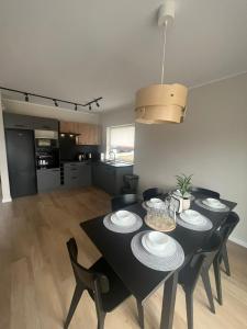 a black dining room table with black chairs in a kitchen at All Season Lasówka in Lasowka