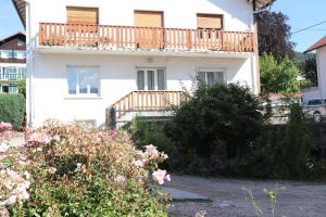 ein weißes Haus mit einem Balkon und Blumen in der Unterkunft Villa le Tramway in Gérardmer