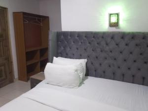 una cama con una almohada blanca encima en Mid Way Best Hotel, en Lagos