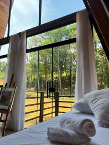 - une chambre avec un lit et une grande fenêtre dans l'établissement Hotel Nativa Eco, à Mandirituba