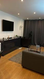 a living room with a couch and a tv at YES Apartments in Crayford