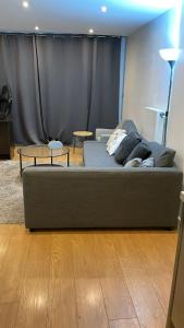 ein Wohnzimmer mit einem Sofa und einem Tisch in der Unterkunft YES Apartments in Crayford
