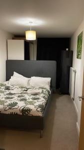 a bedroom with a bed with a green and white blanket at YES Apartments in Crayford