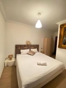 een slaapkamer met een groot wit bed in een kamer bij Cosy & magnifique appartement Marrakech in Marrakesh