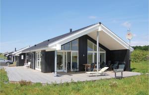 een huis met een houten terras en glazen deuren bij 4 Bedroom Beautiful Home In Rudkbing in Spodsbjerg