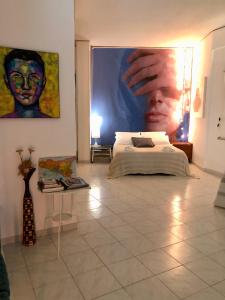 a bedroom with a bed and a large painting on the wall at ArtRoom Garden in Noto +74 photos