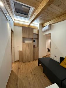 un soggiorno con divano nero e soffitti in legno di La Botte Piccola a Benevento