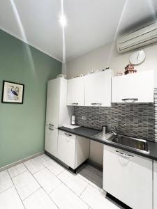 a kitchen with white cabinets and a sink at EASYROOMS ONE in Parma