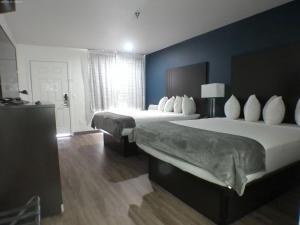 two beds in a hotel room with blue walls at GreenTree Inn of Holbrook, AZ in Holbrook