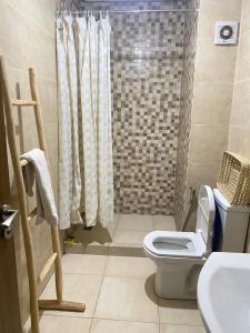 een badkamer met een douche, een toilet en een wastafel bij Cosy & magnifique appartement Marrakech in Marrakesh