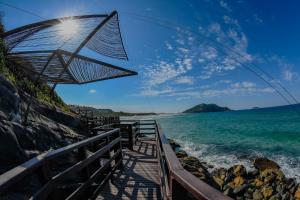 a beach with an umbrella and the ocean at Costao do Santinho Resort All Inclusive in Florian&oacute;polis