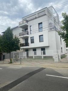 a white building with a balcony on the side of a street at Balcescu Downtown Apartment in Bistriţa