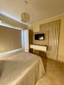 a bedroom with a bed and a flat screen tv at Chill Home IV in Posadas
