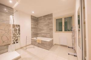een badkamer met een bad, een wastafel en een douche bij Tanière urbaine in Lons-le-Saunier