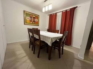una sala da pranzo con tavolo e sedie bianchi di Casa con inmejorable ubicación a Concepción