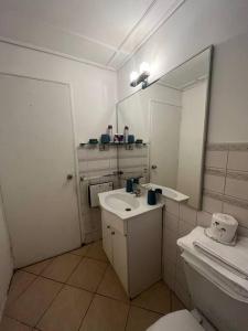 een badkamer met een wastafel, een toilet en een spiegel bij Casa con inmejorable ubicación in Concepción