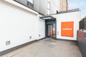 un cartello arancione sul lato di un edificio di easyHotel Glasgow City a Glasgow