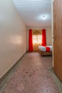 a room with two beds and a window with red curtains at City Space Hotel in Nairobi