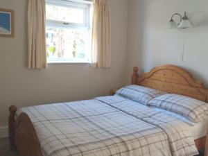 a bed in a bedroom with a window at lockwood house holiday cottages,Dawlish in Starcross