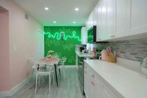 cocina con mesa y pared verde en Tropical Oasis Modern Home with Backyard, en Miami