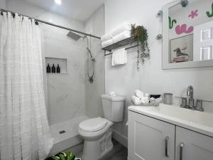 y baño con aseo, ducha y lavamanos. en Tropical Oasis Modern Home with Backyard, en Miami