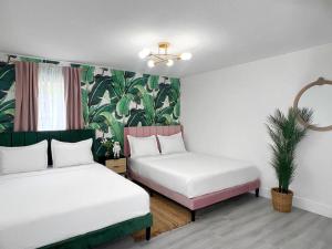 una habitación con 2 camas y una planta en la pared en Tropical Oasis Modern Home with Backyard, en Miami