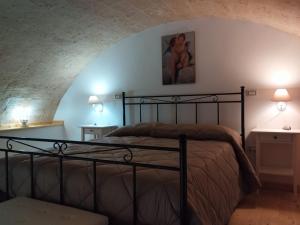 ein Schlafzimmer mit einem Bett, zwei Tischen und zwei Lampen in der Unterkunft Porta Sant'Antonio in Grottaglie