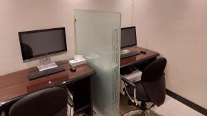 an office with two desks and two computer monitors at InterContinental Dar Al Iman Madinah by IHG in Medina