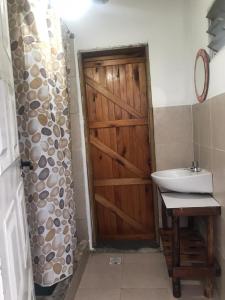 a bathroom with a wooden door and a sink at Campo Verde III in Concordia